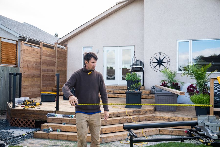 Dmitriy Tsurkin-Appin measuring on a deck and privacy wall project